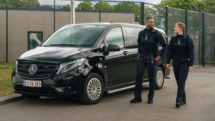 en mandlig og kvindelig transportbetjent i uniform kommer gående